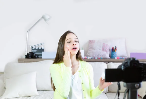 Teen girl blogger cute presenting beauty cosmetic products and broadcasting live video to social network. Focus on the blogger teen girl influencer. Beauty blogger and vlog concept.