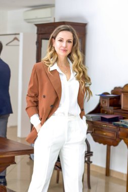 Terzi dükkanındaki kadın ve terzi kıyafetleri bir elbise arıyor. Terzi, işadamı, zarafet kavramı.