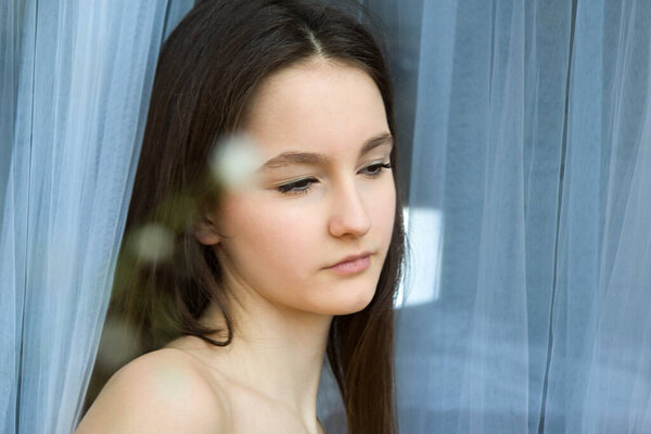 Портрет прекрасной мечтательницы девочки-подростка в окне