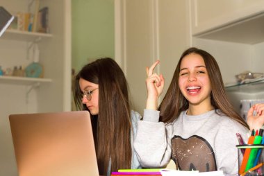 İki genç kız internette dizüstü bilgisayarlarında geziniyor, ilgilerini çekecek ürünler arıyor ve kredi kartıyla alışveriş yapıyor. Gençlerin navigasyon, araştırma ve alışveriş anlayışı