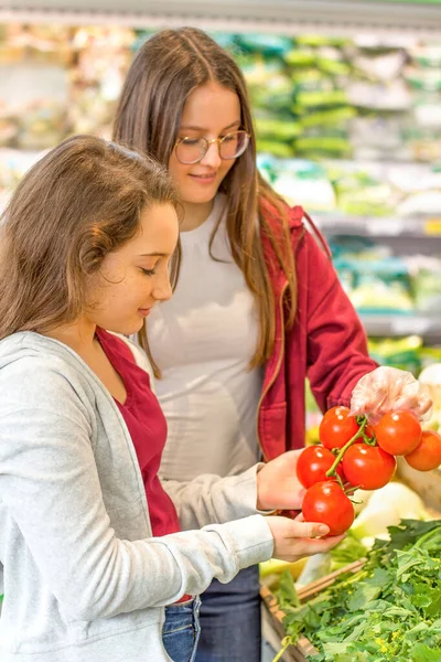 슈퍼마켓에서 쇼핑하는 소녀들 젊은이들은 의식적 유기적 선택을 — 스톡 사진