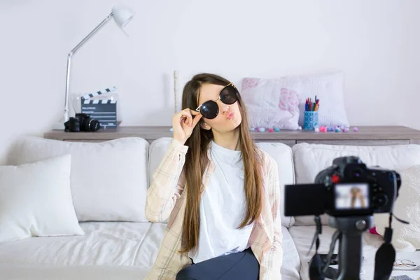 Genç blogcu güneş gözlüğünü test ediyor, sosyal ağlarda canlı yayın yapıyor. Genç kızları etkileyen blogculara odaklan. Güzellik blogcuları ve vlog konsepti.