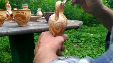 çömlekçi bir fırça ile seramik vazo boyar