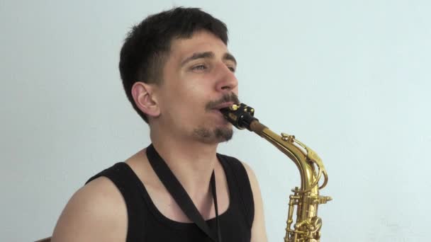 A young man plays the saxophone. close-up — Stock Video