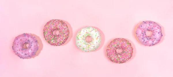 Padrão de cinco donuts envidraçados em fundo rosa suave . — Fotografia de Stock