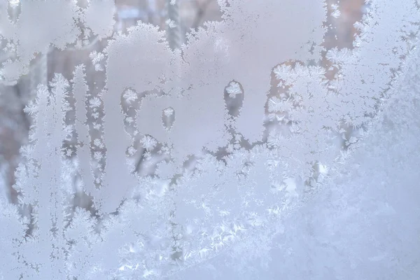 Schöne komplizierte frostige Muster auf dem Fensterglas. — Stockfoto