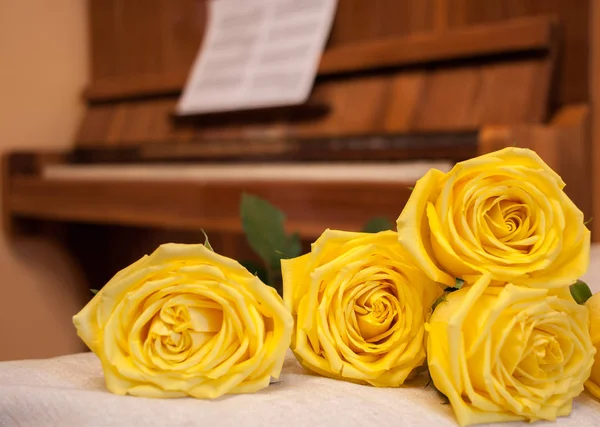 Yellow roses on background of piano with sheet music. — Stock Photo, Image