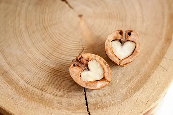 Primer plano dos mitades de nogal en forma de corazón en respaldo de madera — Foto de Stock