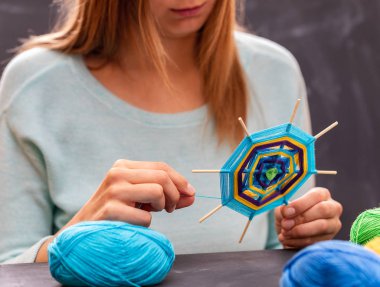 Genç kız renkli iplik dışında el yapımı mandala yapıyor.