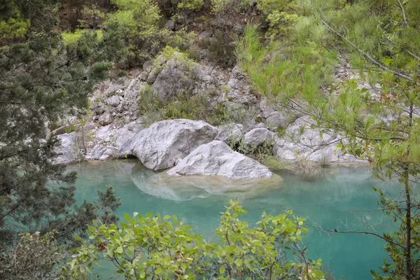 Turkuaz su ve büyük kayalar ile dağ nehri görünümü.