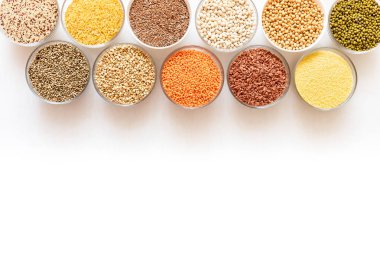 Kopya alanı ile beyaz arka plan üstüne tahıllar, fasulye ve tohum ile Cam kase.