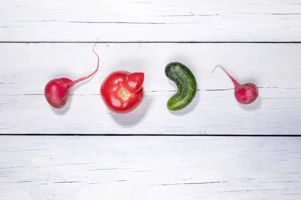 Cuatro verduras feas colocadas en fila sobre fondo de madera blanca . — Foto de Stock