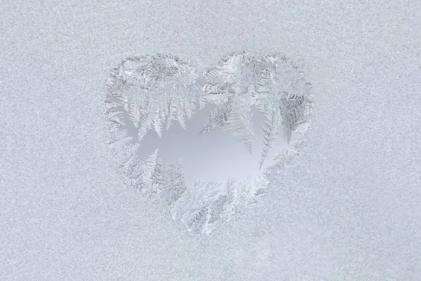 Frostiges Muster in Herzform auf Fensterglas. Selektiver Fokus, horizontale Ausrichtung, Kopierraum. — Stockfoto