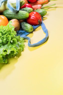 Taze çiftlik sebzeile String çanta kopya alanı ile sarı arka plan üzerinde çapraz yatıyor
