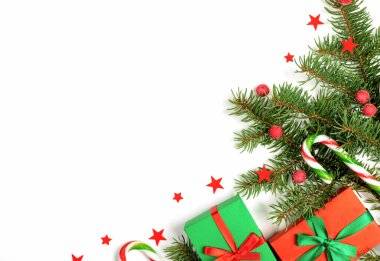 Köknar ağacı, kırmızı böğürtlen ve yıldızlarla Noel kompozisyonu, hediye kutuları, beyaz arka planda geleneksel şeker kamışları.