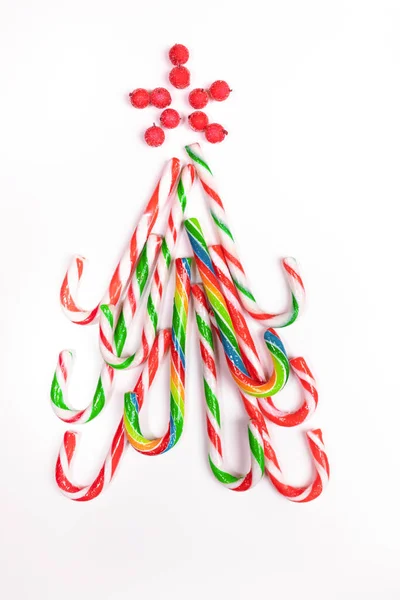 Albero di Natale commestibile di canne multicolore dolci di Natale su sfondo bianco . — Foto Stock