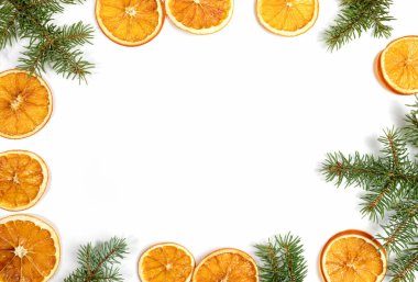 Beyaz arka planda izole edilmiş yeşil köknar dalları ve kurutulmuş portakal dilimleri çerçevesi. Üst görünüm, düz görünüm, kopyalama alanı. 