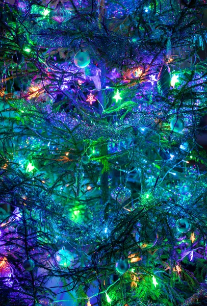 Weihnachtsbaum mit Spielzeug, Girlanden, Lametta in lila-blau-grüner Farbe. Vertikale Orientierung. — Stockfoto