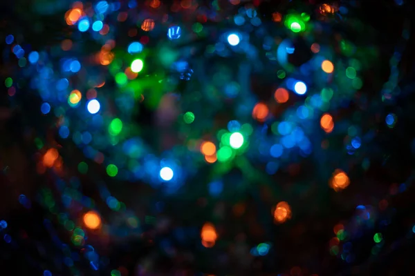 Desfocado enevoado guirlandas árvore de Natal cor roxo-azul-verde na moda no fundo escuro . — Fotografia de Stock