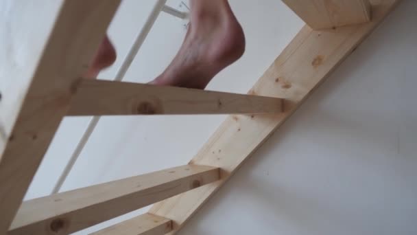 Fille descend sur les escaliers en bois avec pieds nus — Video