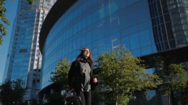 Toplantıya geç kalan genç ve güzel bir iş kadını koşuyor ve saate bakıyor.