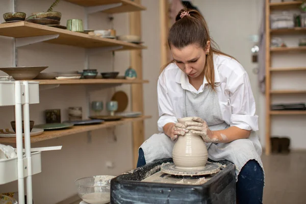 Kobieta ceramist na kole garncarza tworzy naczynia z gliny — Zdjęcie stockowe