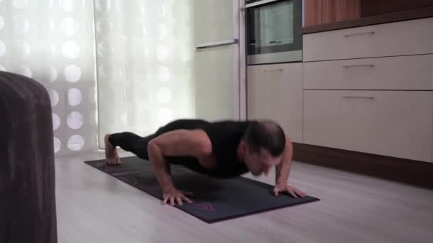 Un joven hace ejercicio en casa durante la cuarentena. — Vídeos de Stock