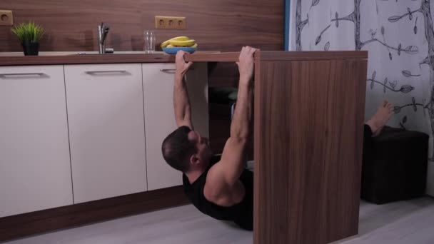 Beyaz spor yapan genç bir adam, mutfak kullanarak Crossfit egzersizi yapıyor. — Stok video