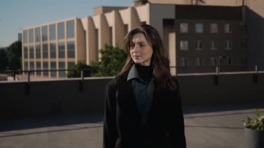 Siyah ceketli genç güzel kız verandada yürür hayatı ve işi düşünür.