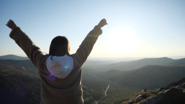 穿着米色夹克、深色头发的女孩在山中迎着日出摆姿势 — 图库视频影像