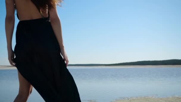 Slim sexy girl in dress poses for the camera against the background of blue sky — Stock Video