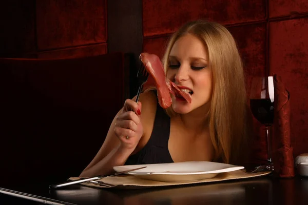 Ελκυστική γυναίκα τρώει ωμό κρέας. Ίντριγκα. Τρώγοντας φαγητό στην κάμερα. — Φωτογραφία Αρχείου