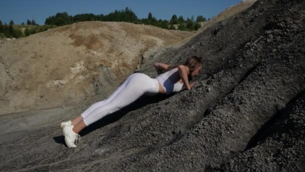 Jong vrij Kaukasisch meisje speelt sport in de natuur, voert push-ups — Stockvideo