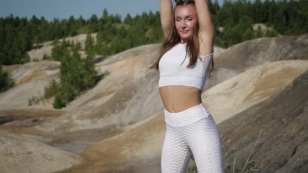 Girl in white tracksuit performs warm-up before training — Stock Video