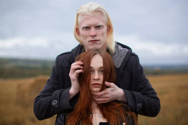 The colourful couple pose while staring at the camera on a wheat field — Stock Photo, Image