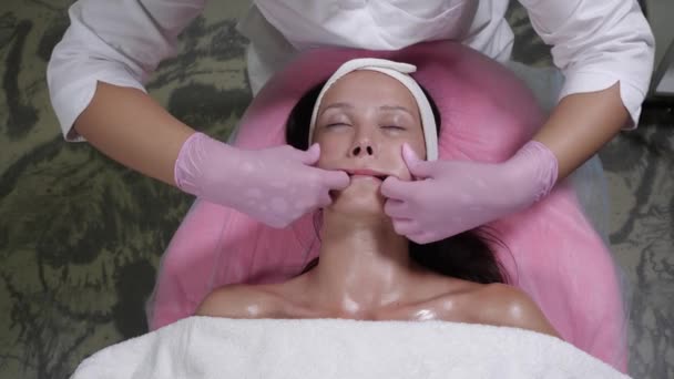 Procedimiento de masaje facial para una hermosa mujer en un salón de belleza — Vídeos de Stock