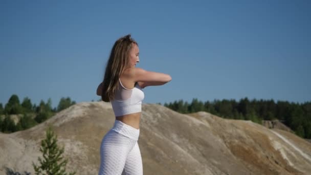 Menina em excelente forma física faz agachamentos cercados por pedreiras de argila — Vídeo de Stock