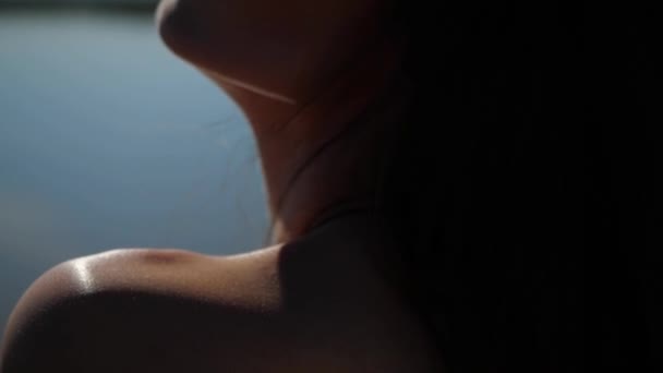 Відблиски сонця падають на жіноче плече, шию, комір — стокове відео