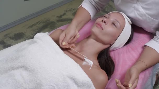 Aplicando uma nata especial antes do procedimento de uma massagem bucal em um salão — Vídeo de Stock