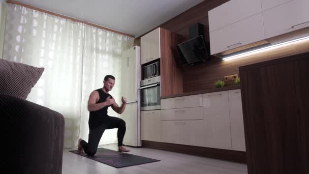 Ένας άνθρωπος εκτελεί μια άσκηση αντοχής σε ένα περιβάλλον στο σπίτι — Αρχείο Βίντεο