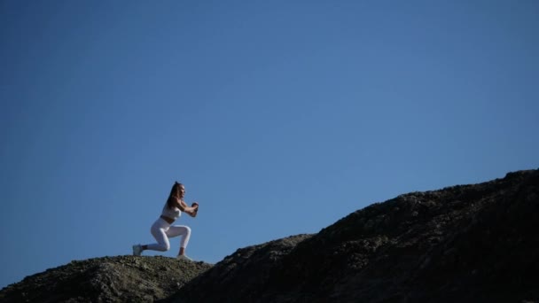 La chica hace un entrenamiento en el borde del acantilado, saltando y se lanza . — Vídeos de Stock