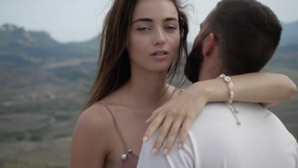 Chica abraza a su hombre, su pelo revolotea en el viento — Vídeo de stock