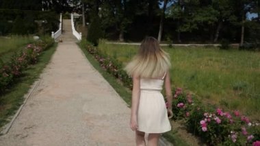Parkta parlak saçlı, narin bir kız koşuyor.