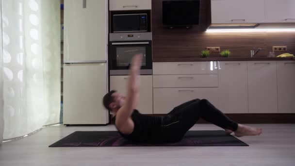 Egy sportoló otthon jógázik a halasana pózban a világjárvány alatt. — Stock videók