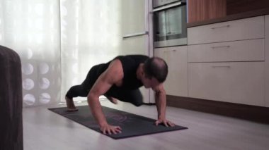 Adam dizinden dirseğine kadar çekerek şınav çekiyor.