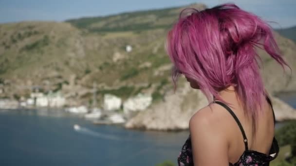 Potret seorang gadis tersenyum dengan rambut merah muda pegunungan dan air di latar belakang — Stok Video