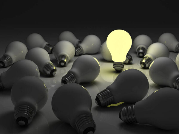 One lit light bulb standing out from unlit incandescent bulbs