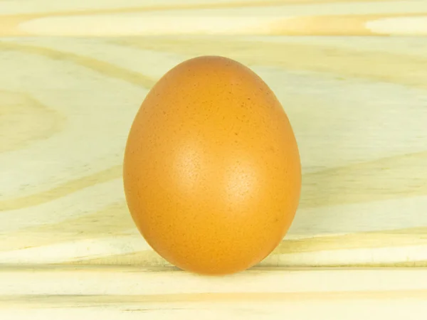 One chicken egg on wooden table — Stock Photo, Image