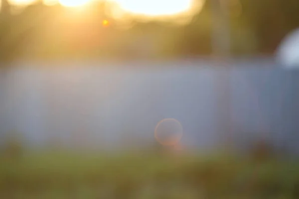 Blurred background with natural sun flare. Abstract blurred background. Abstract blur morning light or summer sunset sky background with bokeh and sun flare.Village landscape blur background