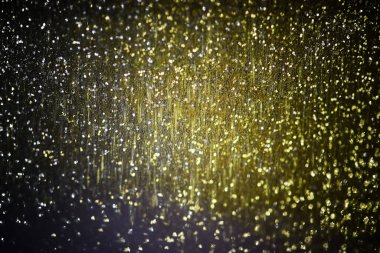 Bulanık siyah ve sarı bokeh arkaplan. Noel ve Yeni Yıl tatili geçmişi. Bulanık simli soyut arkaplan.